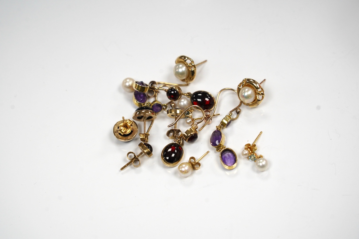 Five assorted modern pairs of 9ct and gem set earrings, including garnet and two other pairs of yellow metal and gen set earrings. Condition - fair to good